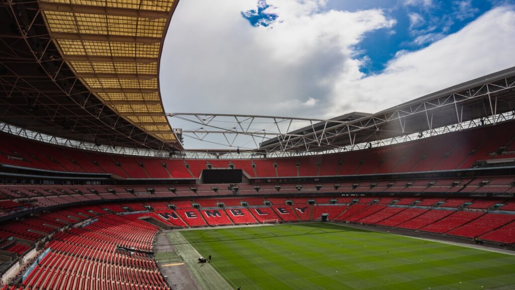 a large stadium with a green field and red seats